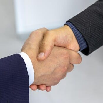 Close-up of two businessmen shaking hands, symbolizing agreement and partnership.